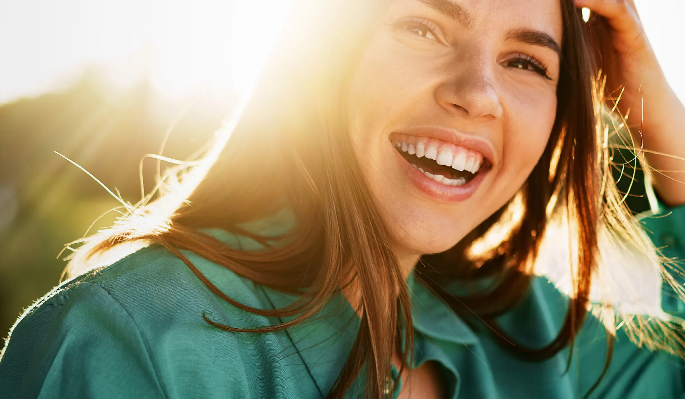 Lachende Frau fasst sich in die Haare